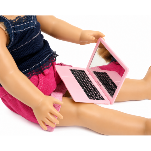 Pink toy laptop computer with reflective screen and realistic keyboard accessory for 18-inch dolls, displayed on the lap of an American Girl-sized doll on a white background.